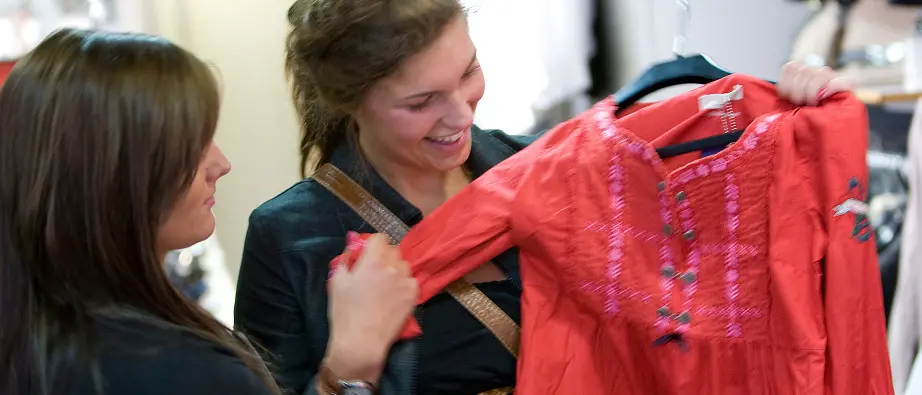 En kvinna håller i en tröja i en butik