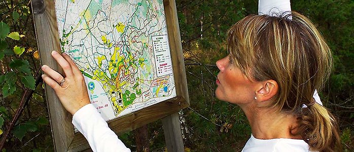 Kvinna läser en karta över naturområde